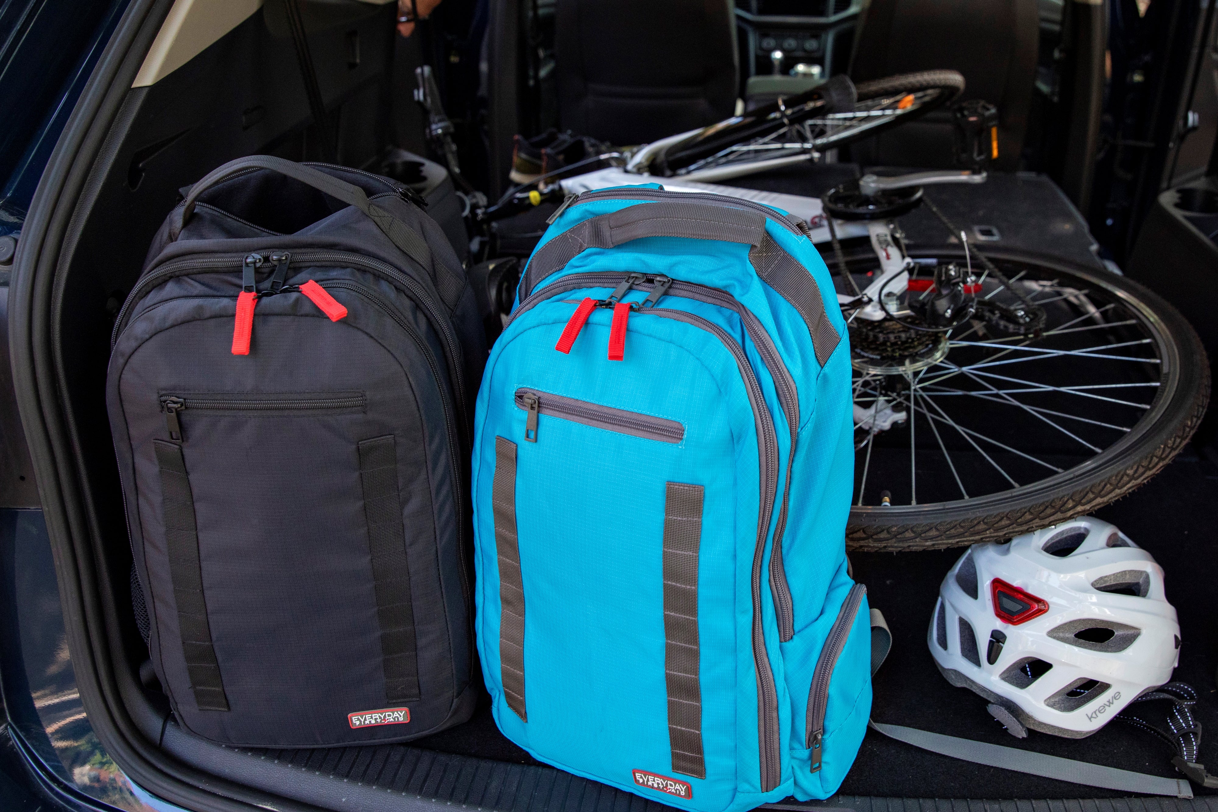 black and blue first aid backpack in back of car with bike and bike helmet
