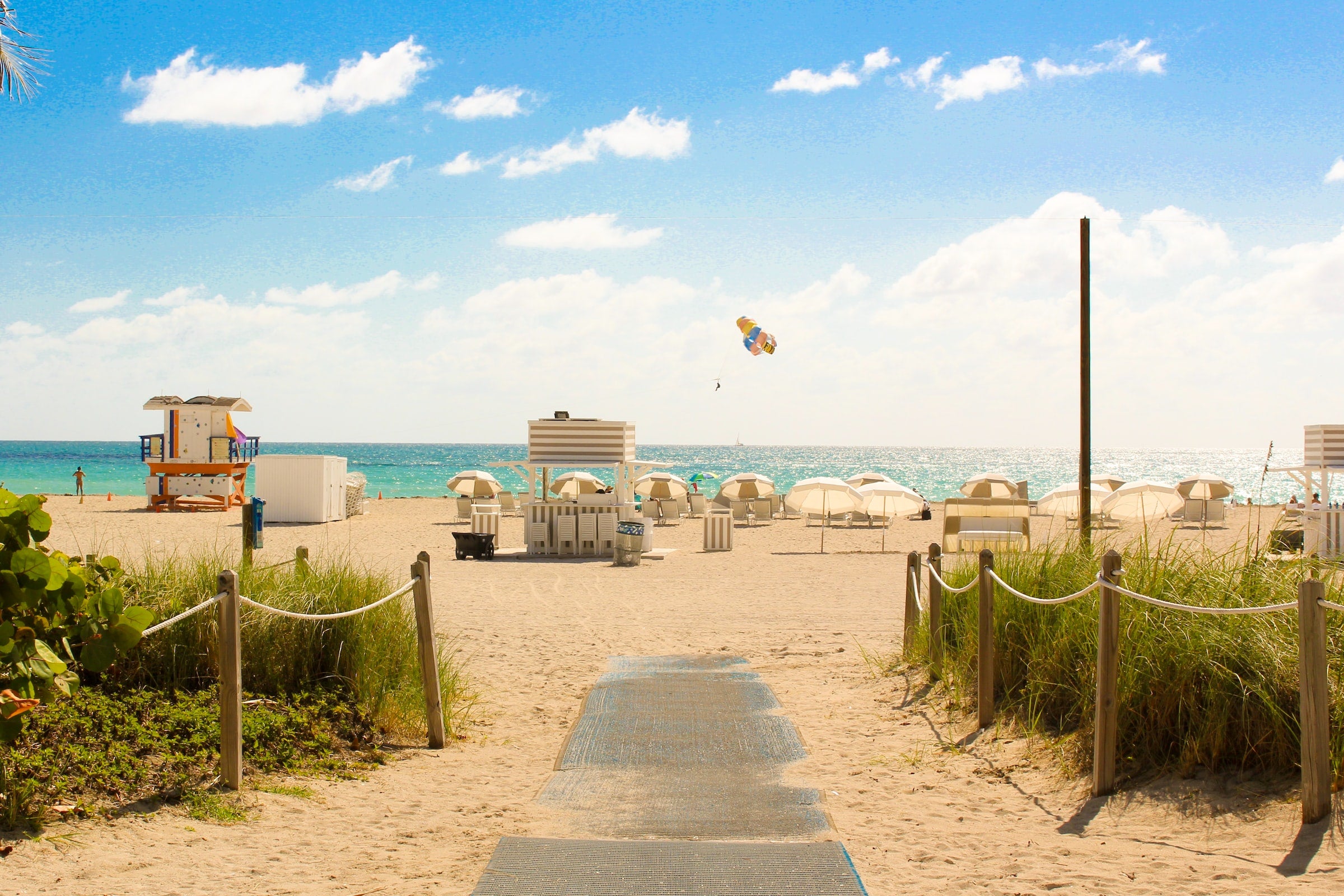 sunny beach with chairs and ocean