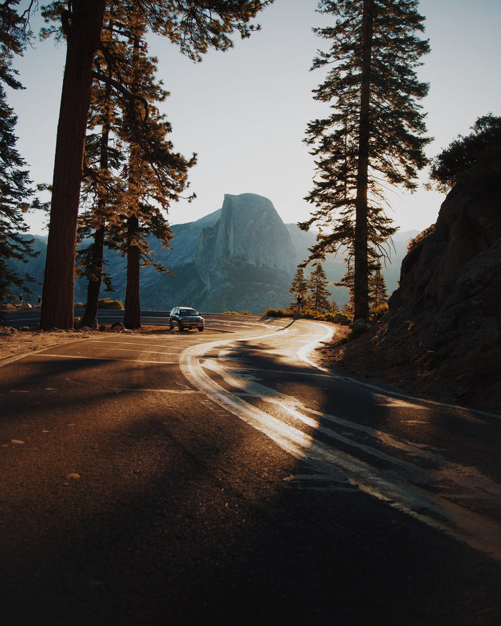 mountain roadway with trees and a car